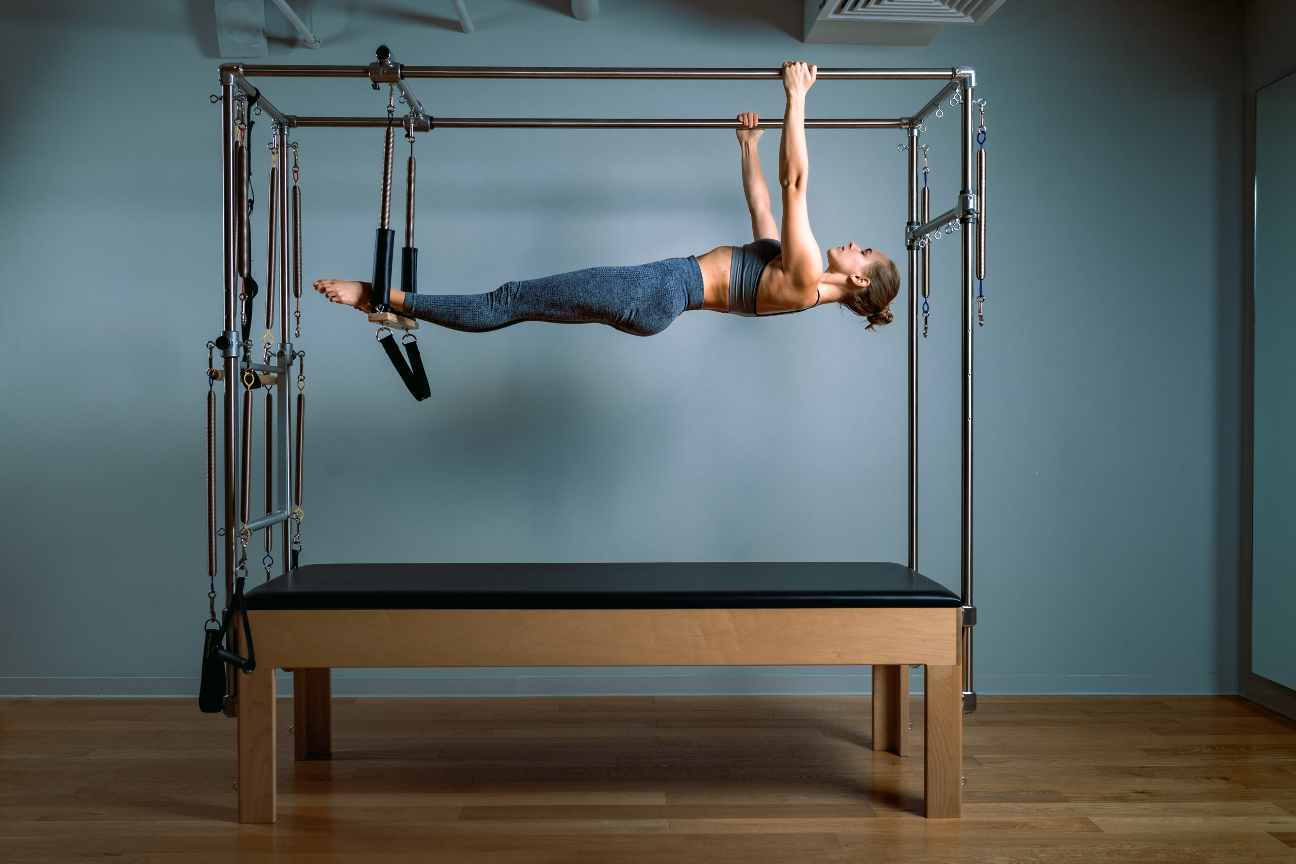 Palates trainer girl posing for a reformer in the gym. Fitness concept, special fitness equipment, healthy lifestyle, plastic. Copy space, sport banner for advertising